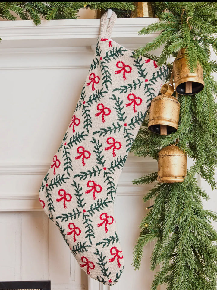 Holiday Trellis Stocking in cream knit with a green pine bough and red bow trellis pattern.
