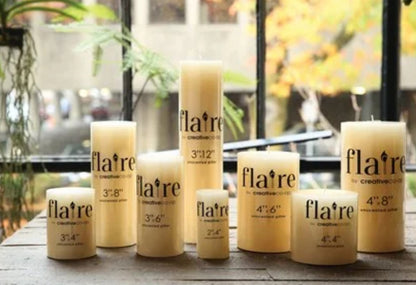 Cream-colored Flaire Unscented Pillar Candles, long-burning, round, available in multiple sizes.