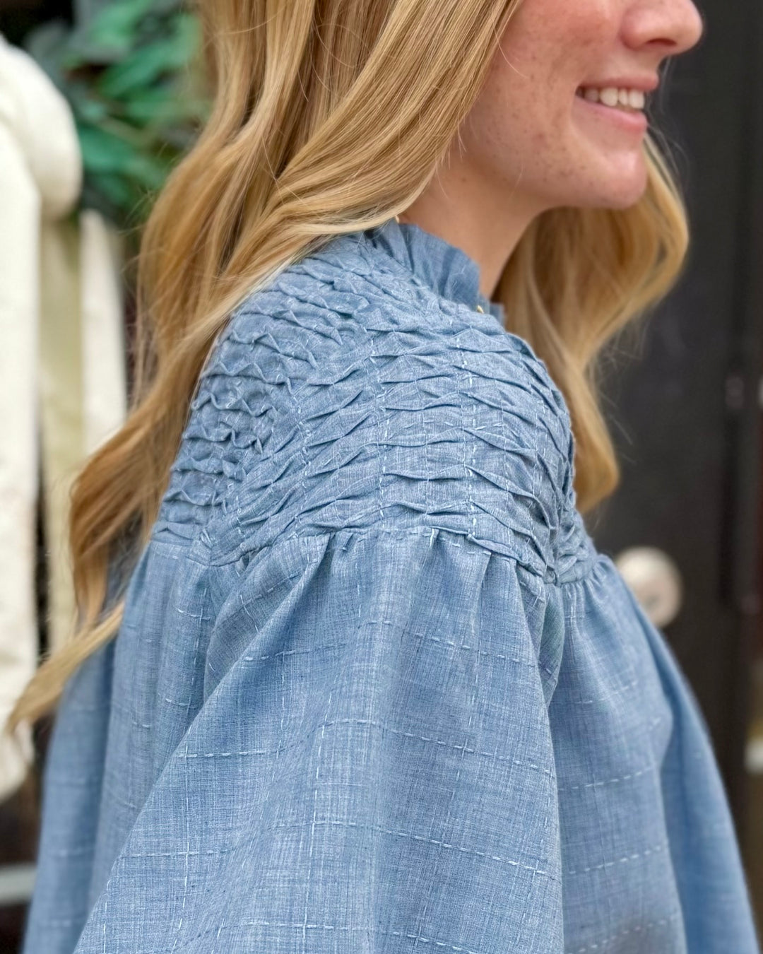 Bubble Sleeve Blouse: blue top with textured fabric, bubble sleeves, and smocked shoulders; available in sizes XS-XL.