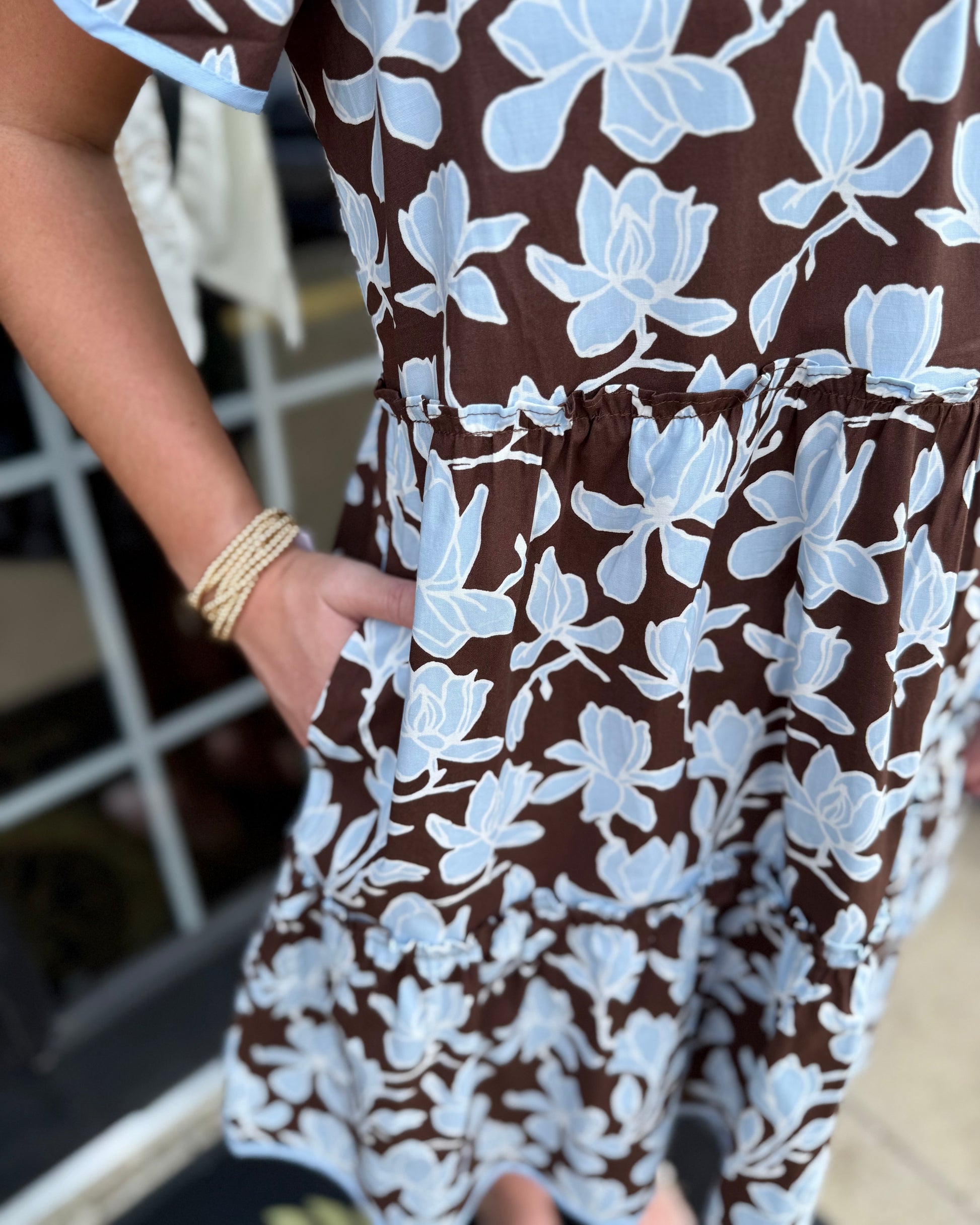 Ivy Growing Grace Blue Mini Dress with a relaxed brown silhouette, light blue floral patterns, and delicate light blue trim. Available in sizes XS–XL.