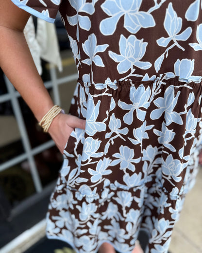 Ivy Growing Grace Blue Mini Dress with a relaxed brown silhouette, light blue floral patterns, and delicate light blue trim. Available in sizes XS–XL.