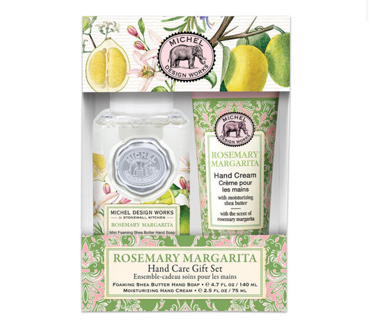 The Rosemary & Margarita Hand Care Gift Set from Michel Design Works features a mini foaming hand soap with sparkling citrus notes and a moisturizing hand cream. The packaging showcases vintage-style illustrations of lemons, rosemary, and green foliage. Available sizes: Mini.
