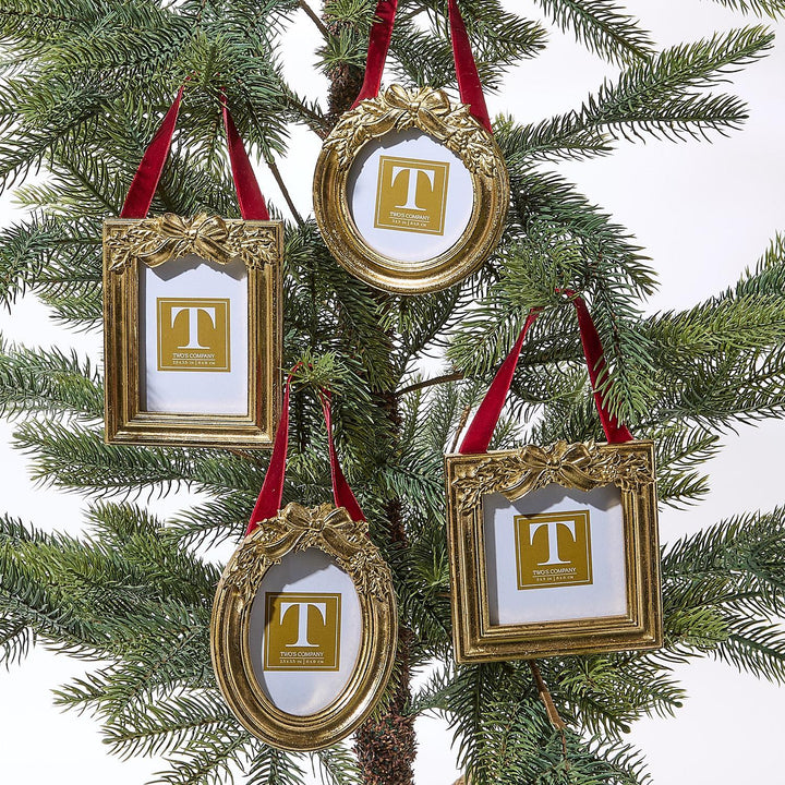 Gold-toned metal holly leaves ornament photo frames with red velvet ribbons.