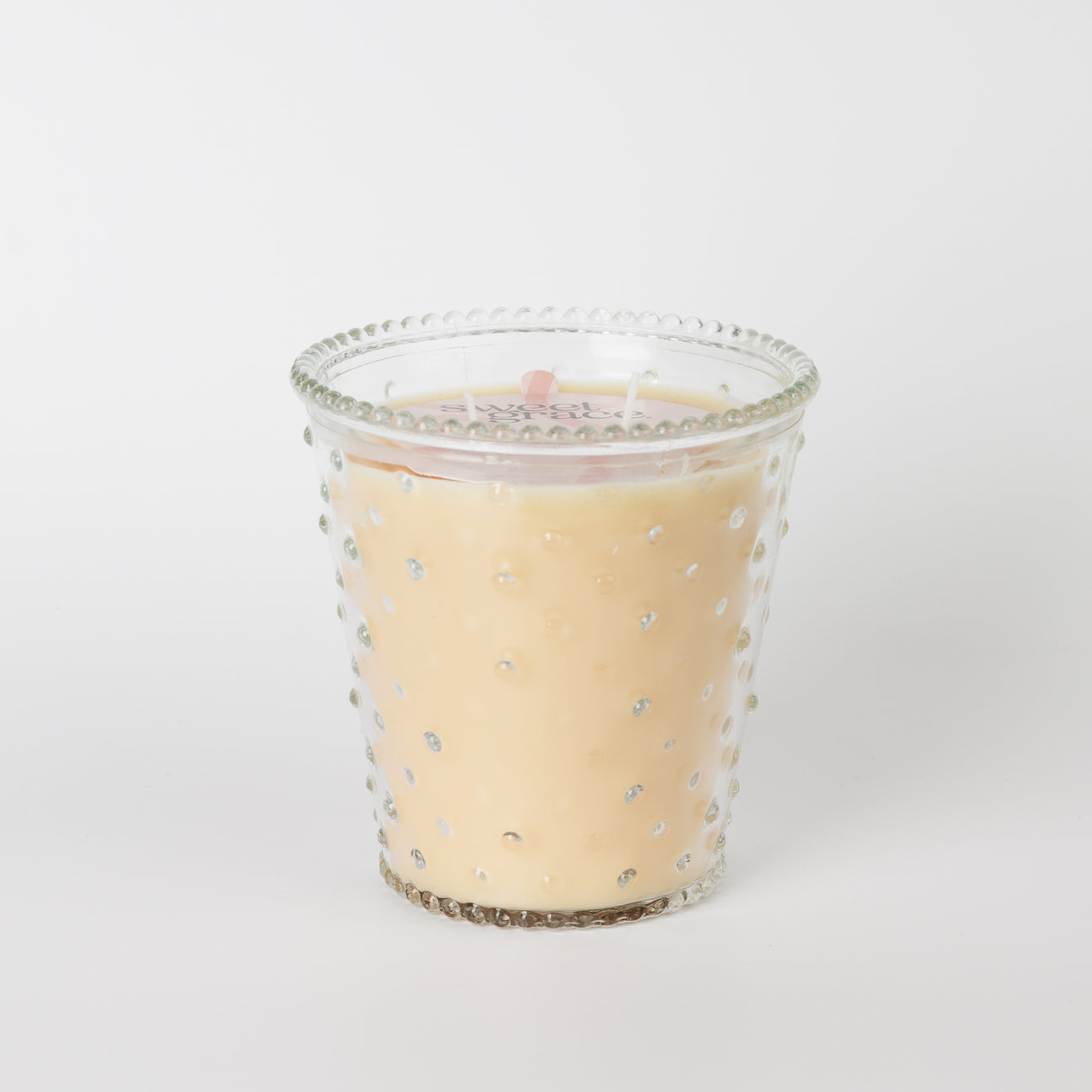 Sweet Grace Collection Candle #80: cream soy-blend wax in clear glass with raised dots. Available in multiple sizes.