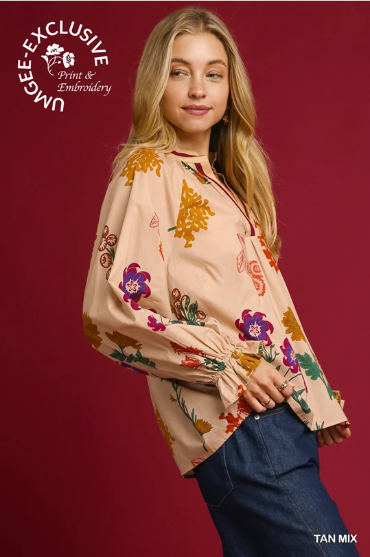 Tan v-neck blouse with colorful floral print and embroidery. "JUNGEE EXCLUSIVE." Available in sizes XS-XL.