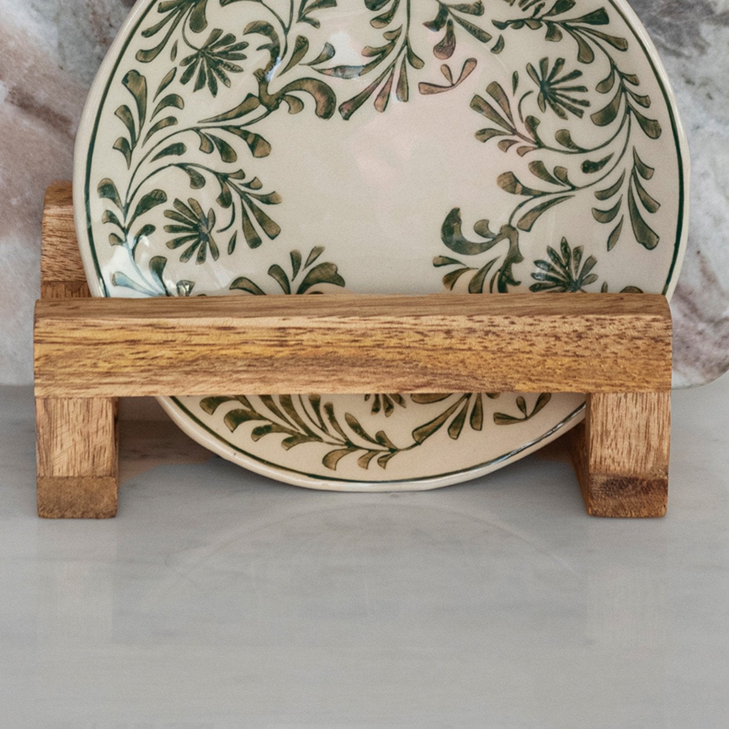 Mango wood stand with 3 sections holds a ceramic plate with green leafy patterns. Available in small, medium, and large sizes.