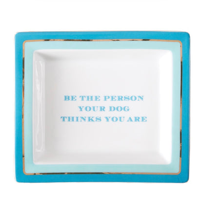 Square porcelain tray with a turquoise rim and the phrase “BE THE PERSON YOUR DOG THINKS YOU ARE” in bold blue letters. Available size: 6"x6".