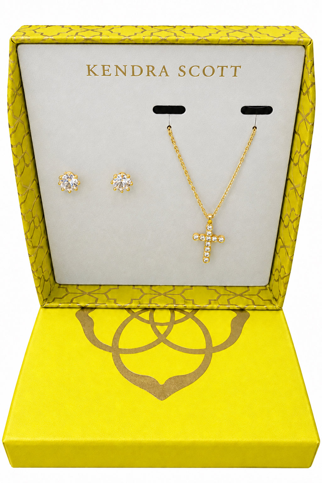 Cross Cailin Gift Set: gold metal with white CZ, stud earrings, and cross crystal necklace in yellow Kendra Scott box. Sizes available: not specified. Display card reads: “$110 Value: $140.”.