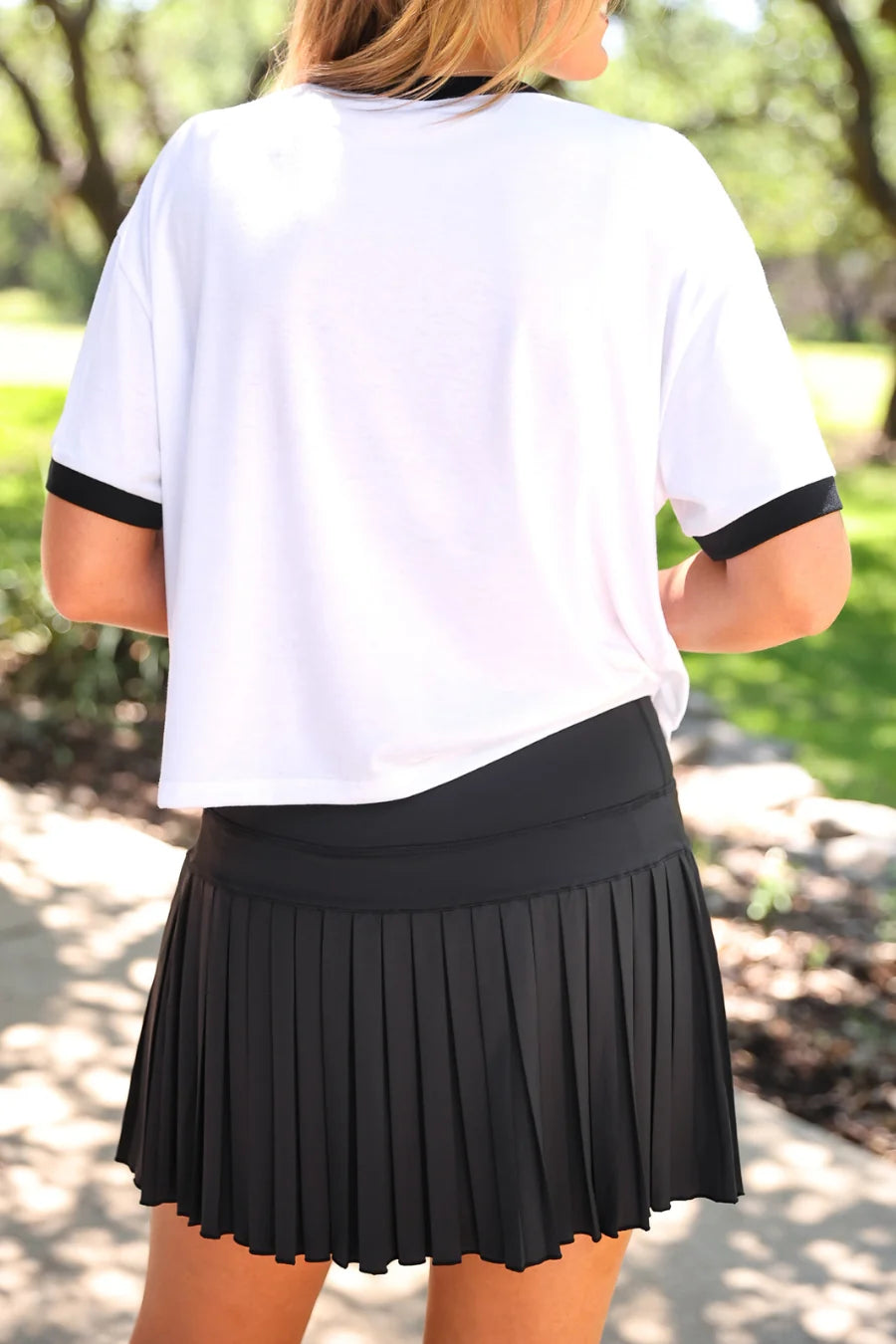 After Dark Pleated Tennis Skort in black, featuring pleated design. Available in sizes XS-XL.
