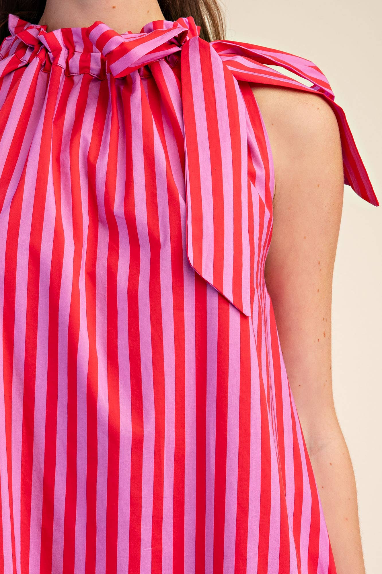 Close-up of the Navy Stripe Midi Dress with sleeveless ruffle neck tie. Available in sizes S and up.