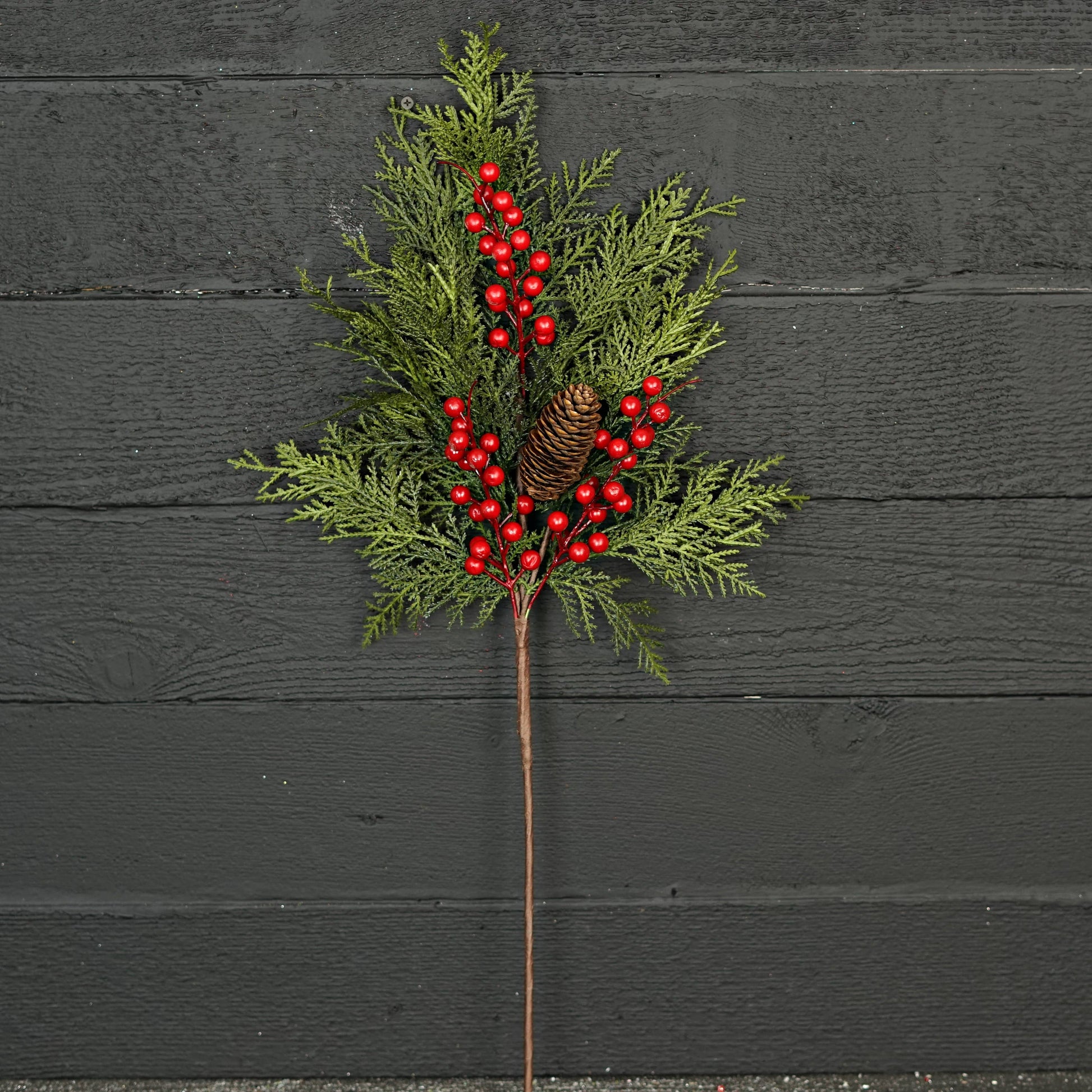 The Superior Real Touch Mix Cedar is a festive 29-inch branch with lifelike cedar sprigs, green pine branches, a small pine cone, and vibrant red berries on a single stem. Available in 29-inch size.