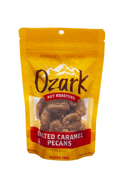 Yellow 3oz Ozark Nut Roasters Salted Caramel Pecans bag, gluten free label, clear window shows pecans.