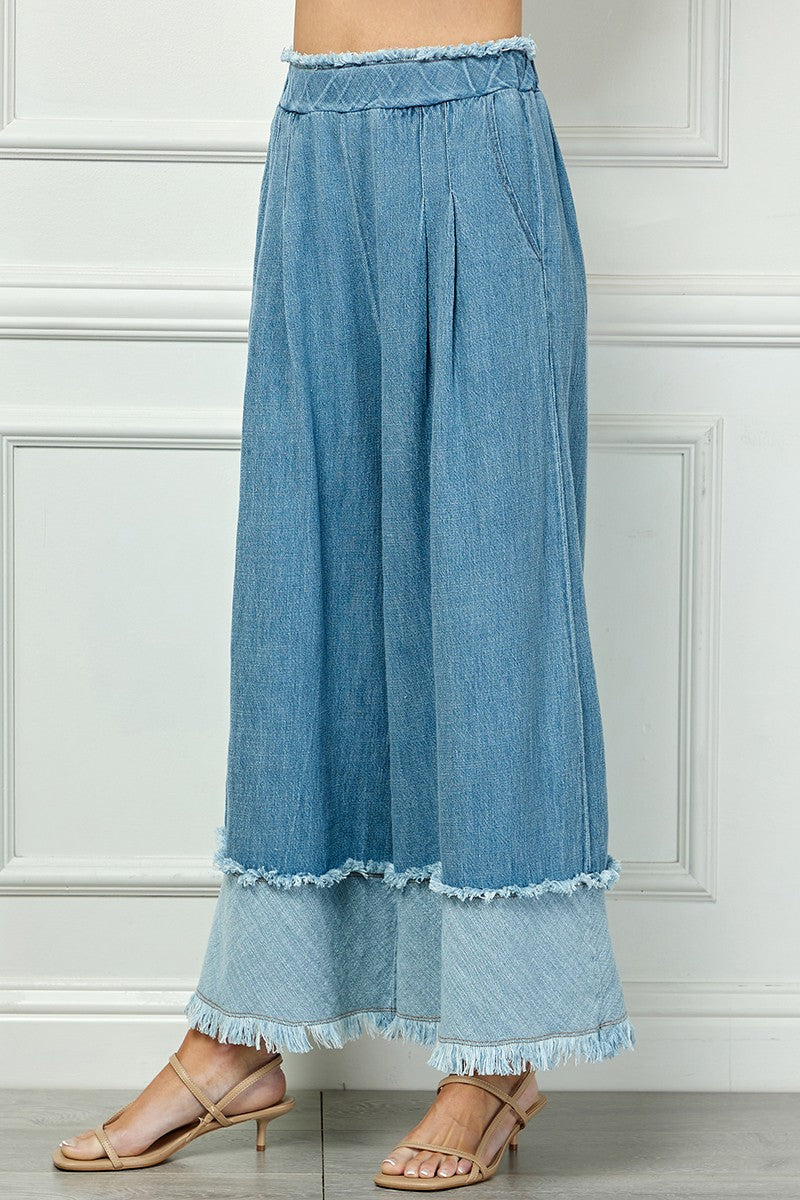 Fringe Detail Wide Denim Pants with frayed hems and tiered bottoms. Available in sizes XS-XL.