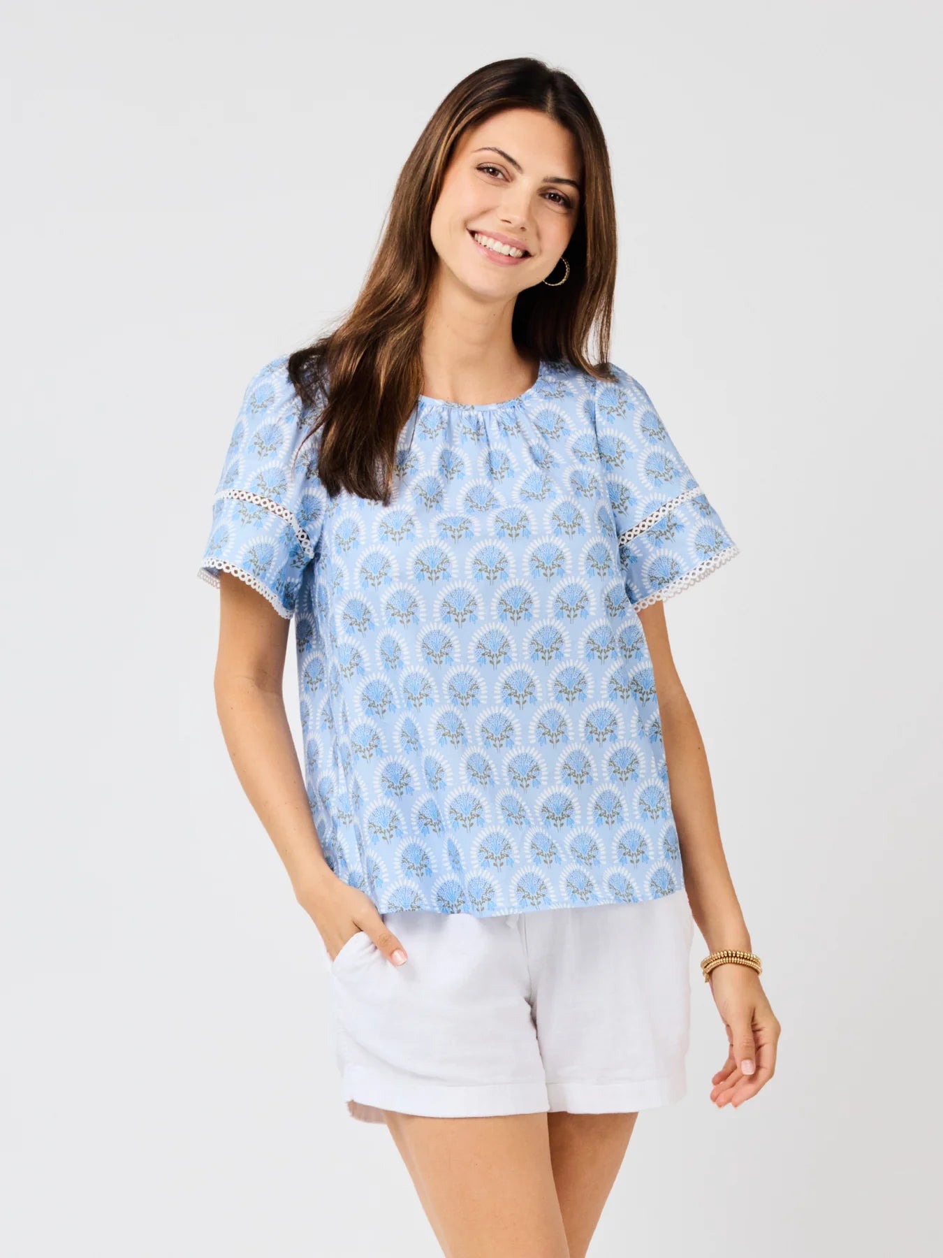 Tabby Sunshower Flora Blue Top with white trim and eyelet details. Available in sizes XS-XL.