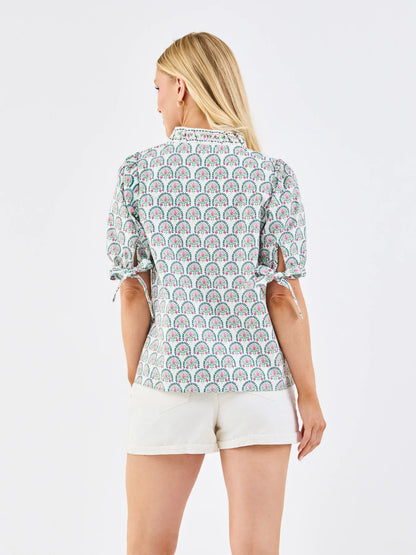 Brynn Sunshower Flora White Top with puff sleeves and ruffle mock neckline. Available in sizes XS–XL.