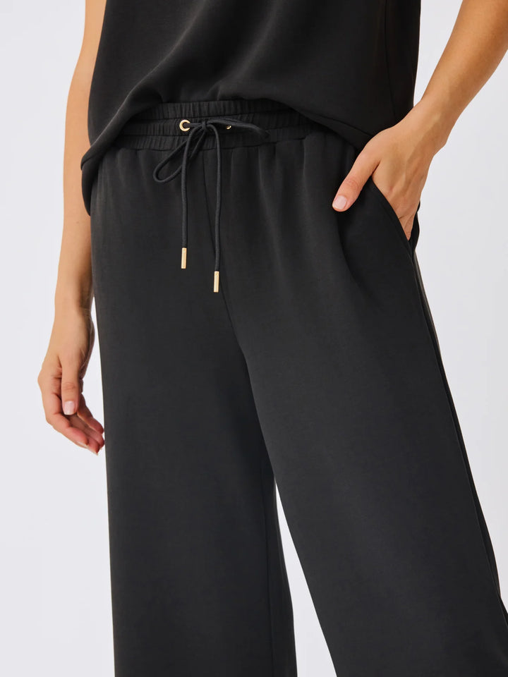 Sabrina Cropped Pants in black with wide legs, elastic waistband, gold-tipped drawstrings. Sizes: XS-XL.