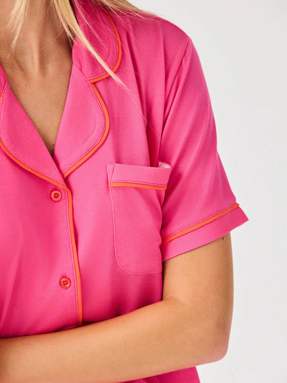 Charlotte Pink Shorts Set: bright pink modal, orange piping, chest pocket, pink buttons. Sizes XS–XL.