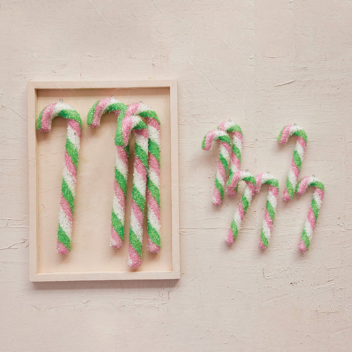 Set of six 6” pink, white, and green glittery candy cane ornaments.