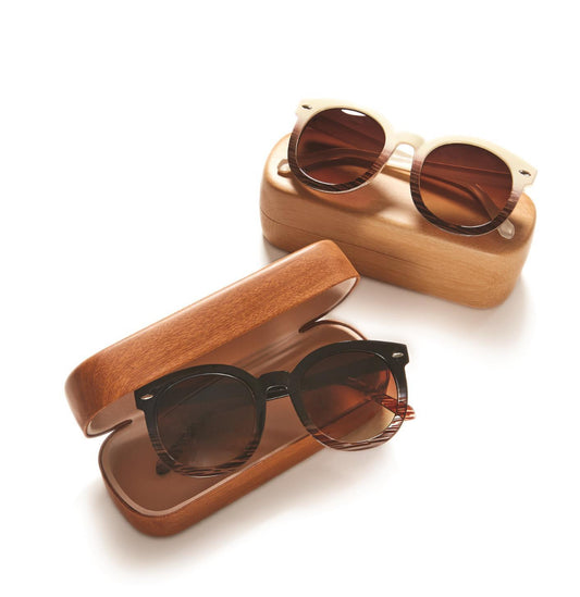 Two pairs of Fade Frames Sunglasses with cases. One with faux bone frame, the other with assorted color frames. Features round polycarbonate lenses. Comes with wooden cases, displayed on a white surface. Sizes available: one size fits all.