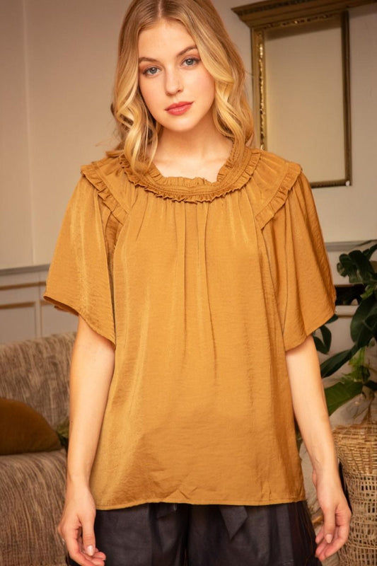 Loose golden short-sleeved blouse with wide sleeves and double ruffle neckline. Available in sizes XS–XL.