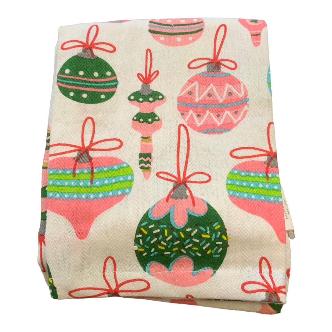Folded white Christmas hand towel with pink, green, and blue ornament pattern.