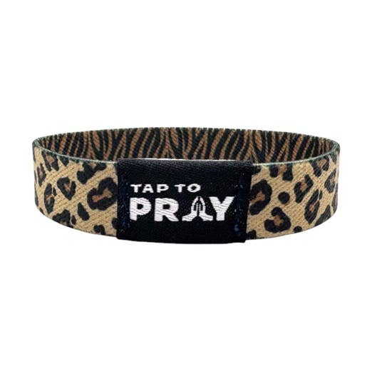 Leopard-print wristband with black patch, "TAP TO PRAY" in white, praying hands icon. Sizes: S, M, L.