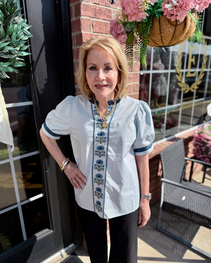 Bluebell Embroidered Blouse with delicate floral embroidery and subtle puff sleeves. Available in sizes XS–XL.
