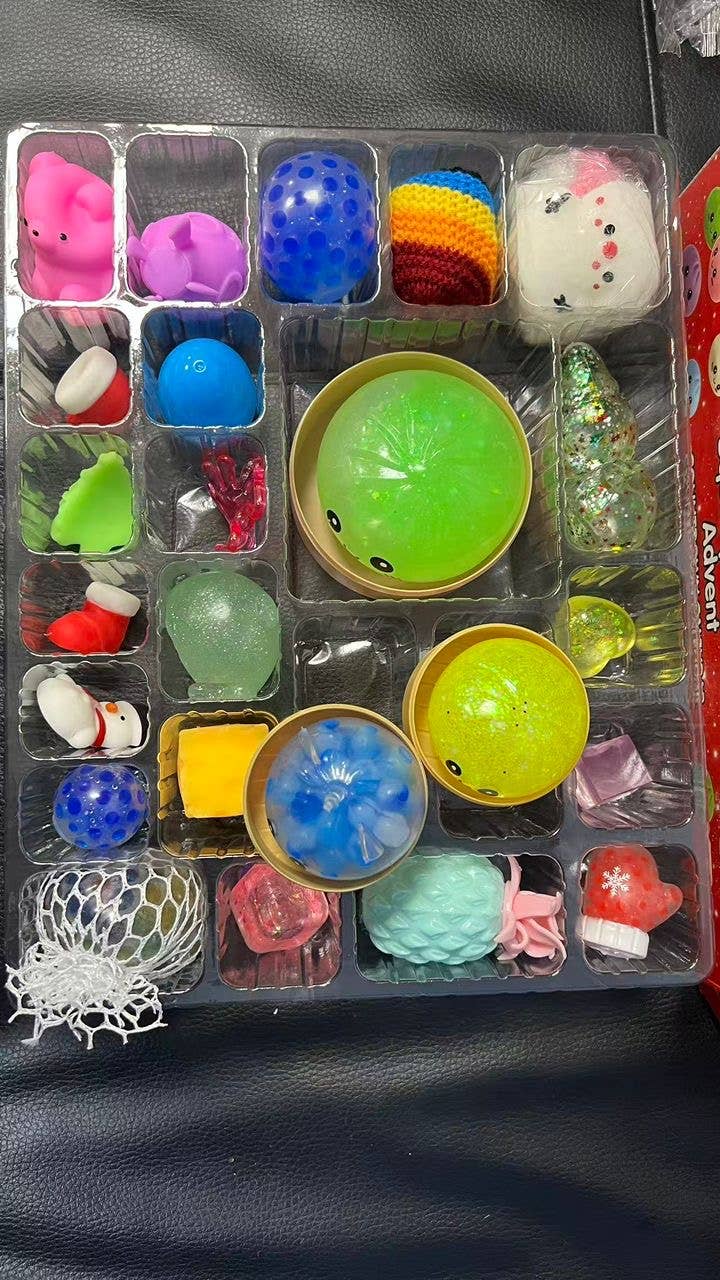 Squishy Mystery Calendar Countdown Days featuring assorted animal, textured, and holiday squishy toys in a plastic tray.