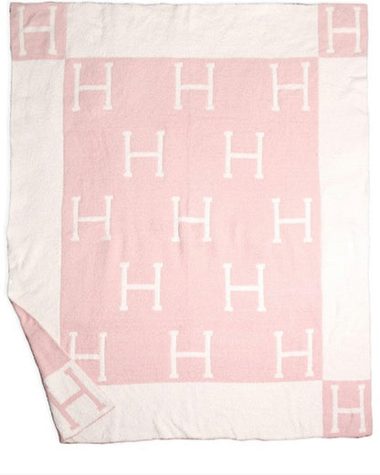 Pink and white poly microfiber throw, 50" x 60", reversible, with large white "H"s and wide pink border with corner "H"s.
