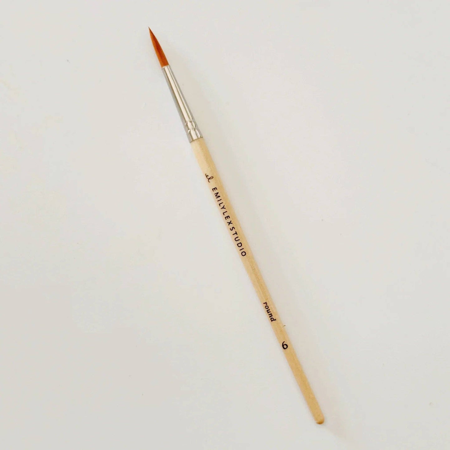 Round-tipped brush with synthetic taklon bristles, wooden handle marked "EMYLEE STUDIO round 6," silver ferrule; sizes 0–12.