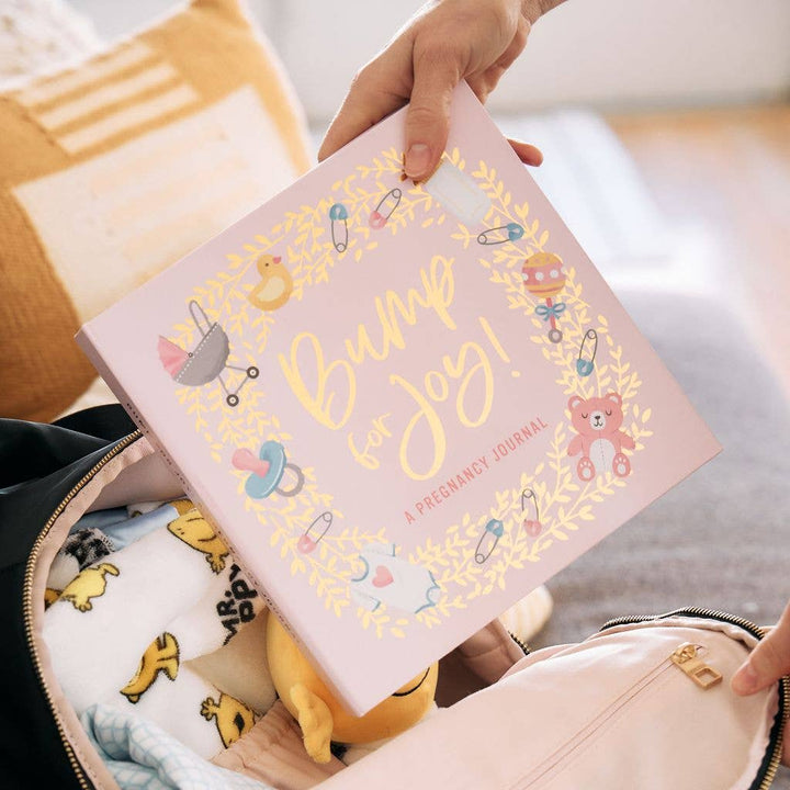 Bump for Joy: A Pregnancy Journal (Pink), available in standard size, shown held above an open bag.