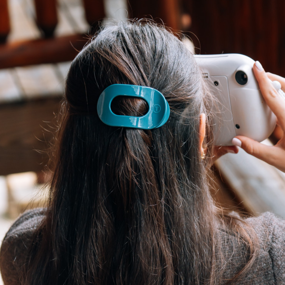 Teal With It Small Flat Round Hair Clip securing hair; available in small size.