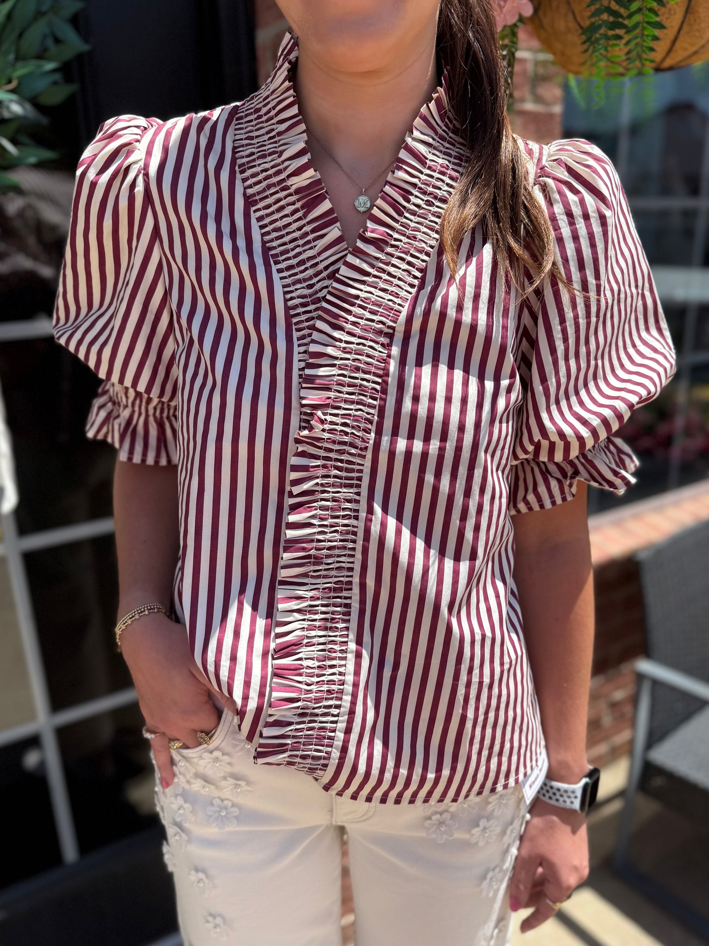 Maroon Striped Cinched Blouse with puff sleeves, ruffled trim, and button-down front; vertical maroon and white stripes. Available in sizes XS-XL.