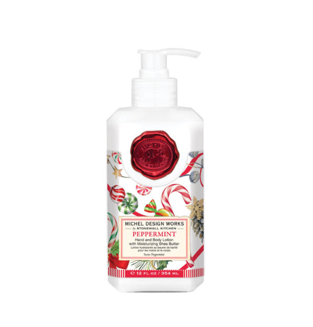 White bottle of Peppermint Hand & Body Lotion by Michel Design Works. Festive holiday label with candy canes, pine cones, and stars. Red pump, eucalyptus & peppermint scent. 12 fl oz (354 mL). Red wax seal design.