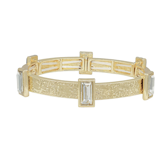 Hammered gold stretch band with rectangular clear gemstones and textured finish. Available sizes: S, M, L.