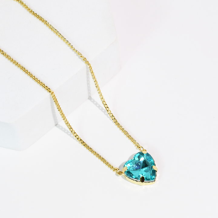 The Berry Crush Necklace: Aqua has a gold dainty chain and heart-shaped blue crystal pendant. Available in 16", 18", and 20" sizes.