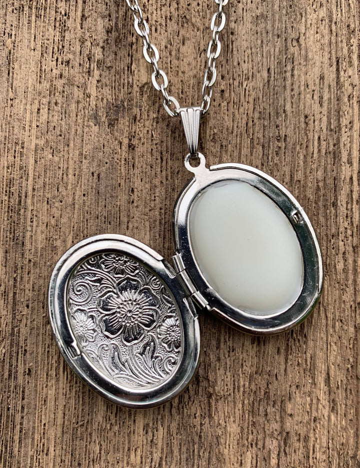 Antiqued silver locket with solid gardenia perfume, oval and floral engraved; available in small and medium sizes.