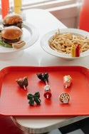 Chews Wisely Minis: red tray holding six food-themed rings. Available sizes: mini.