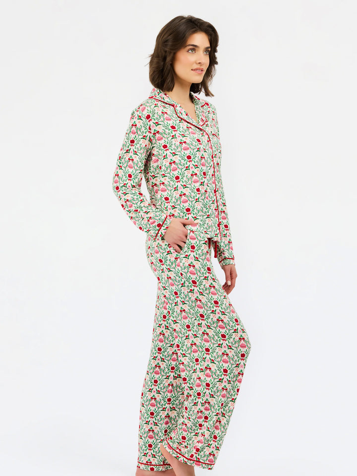 Charlotte Trimmed with Joy long-sleeved pajama shirt and matching pants in a green and red ornament print with red piping.