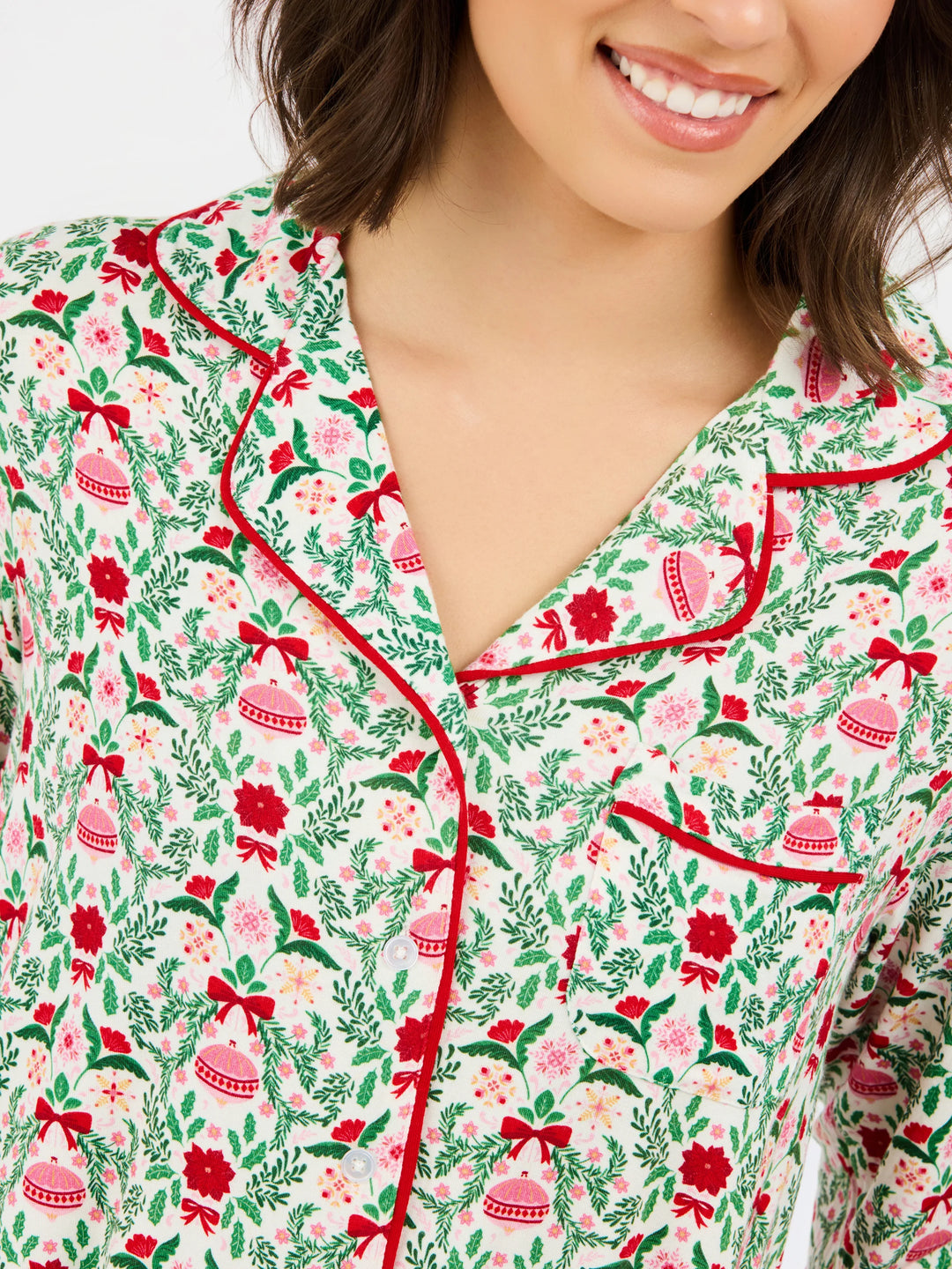 Charlotte Trimmed with Joy Pants Set: button-up pajama top in a white print of red poinsettias, green foliage, and Christmas ornaments with red piping.