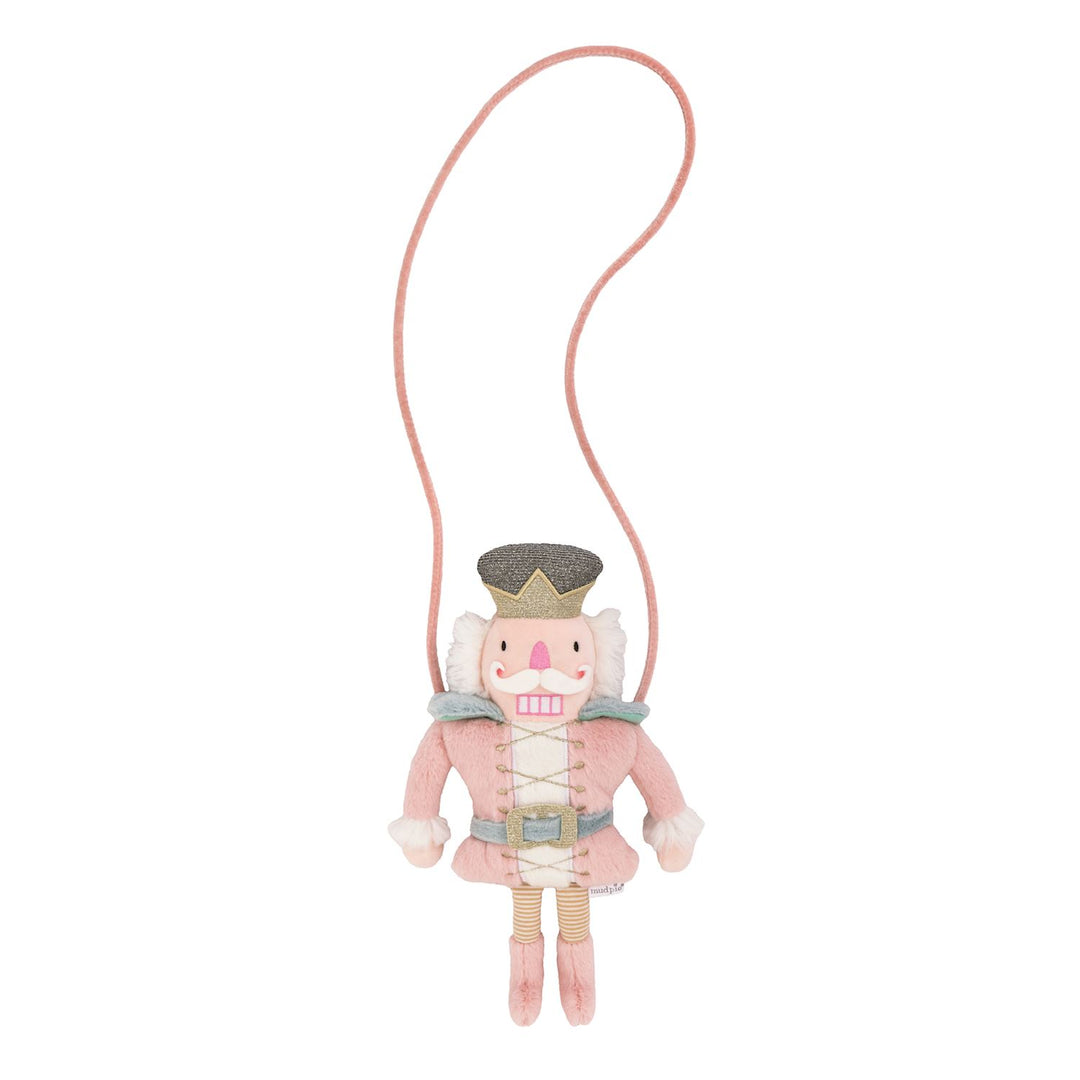 Pink Nutcracker-shaped plush purse with glittery crown, belt, and long strap.