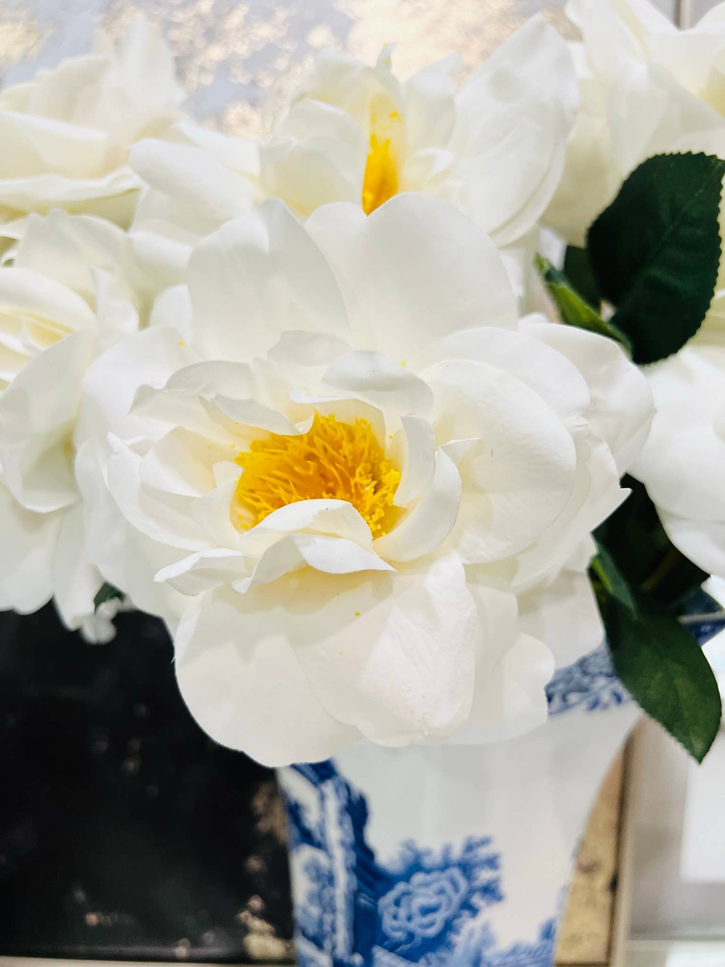 Elegant lifelike Artificial Real Touch Orlane Rose-15" Long: Pure White with bright yellow centers, arranged in a blue and white porcelain vase.