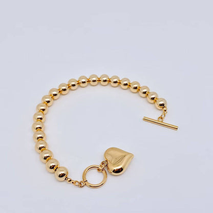 18K gold plated heart charm bracelet with 8MM beads, toggle clasp, and shiny charm. Available in multiple sizes.