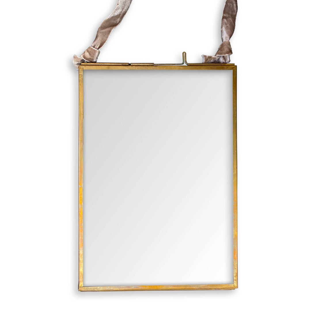 Handcrafted brass and glass photo frame, 4”x6”, suspended by a beige ribbon tied at the top.