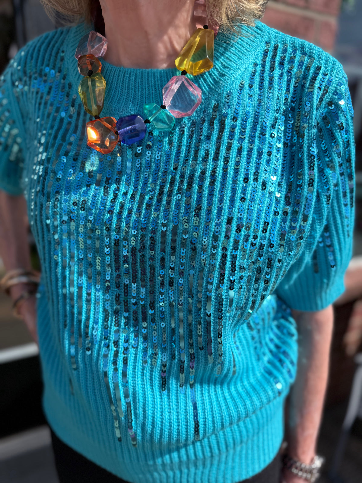 Colette Sequin Sweater with bright blue sequins and a shimmering finish. Available in sizes XS-XL.