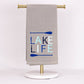Gray Lake Life Oar Hand Towel with "LAKE LIFE" in blue/aqua and two blue oars. Sizes: not specified. Machine wash cold.