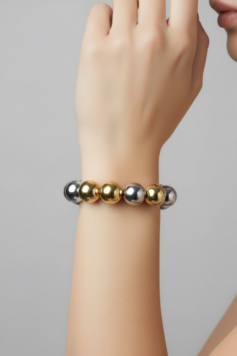 Water resistant stretch bracelet with alternating shiny silver and gold beads. Available sizes: S, M, L.
