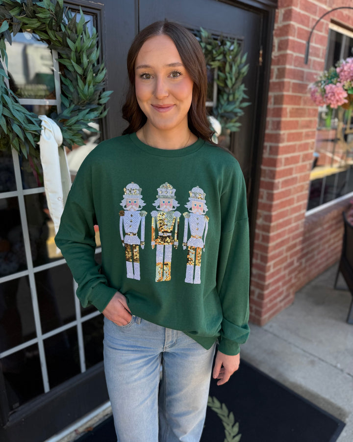 Dark green Alpine Nutcracker sequin sweatshirt featuring three sequined nutcrackers. Available in all sizes.