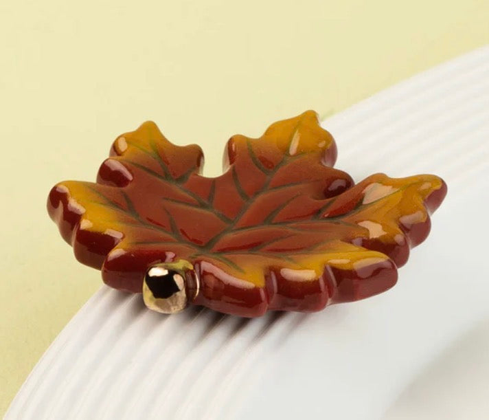 Ceramic maple leaf-shaped Nora Fleming Minis napkin holder in red and yellow tones; available in standard mini size.