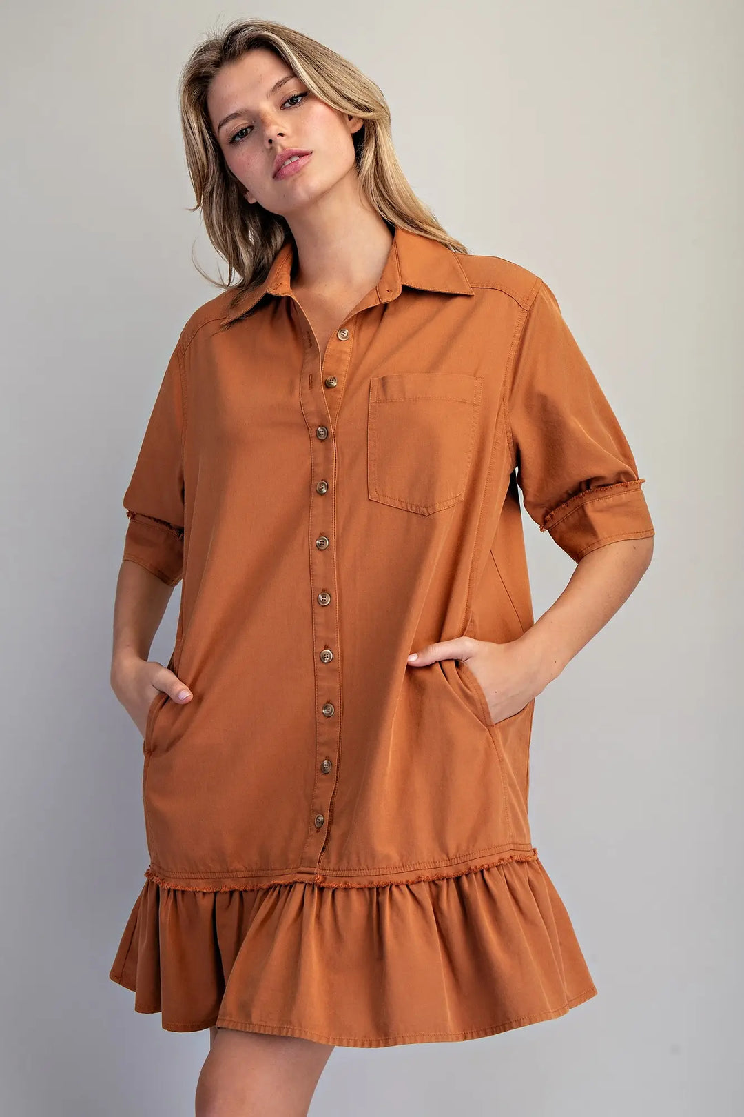 Clay Button Down Mini Dress: loose fit, rust color, short sleeves, front buttons, ruffled hem. Available in sizes XS-XL.
